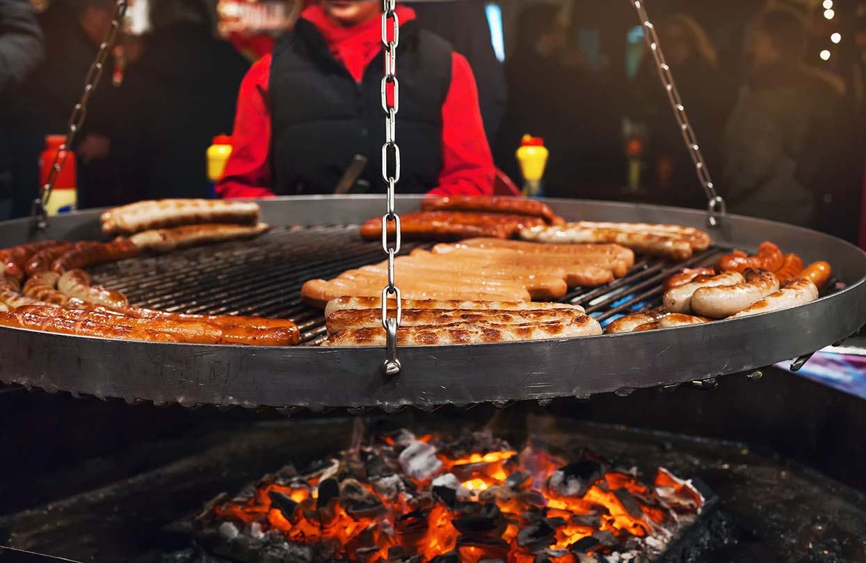 Grilling typical German sausages in the Christmas fair in Hamburg, image by tianalima, Shutterstock | World Travel Magazine Grilling typical German sausages in the Christmas fair in Hamburg, image by tianalima, Shutterstock